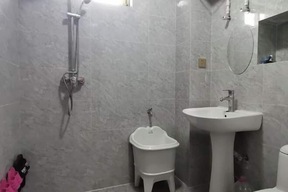 A bathroom with a shower, a sink, and a toilet.
