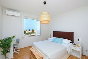 Une chambre à coucher comprenant un lit, une table de chevet, une chaise et une fenêtre donnant sur un paysage agréable.