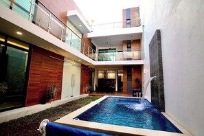 Ein modernes Gebäude mit Pool auf dem Dach und Wasserfall.