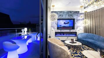 Ein modernes Interieur mit einer Sitzecke, einem an der Wand befestigten Fernseher und einer dekorativen Leuchte.