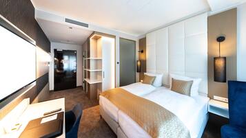 A hotel room with a bed, desk, chair, and a walk-in closet.
