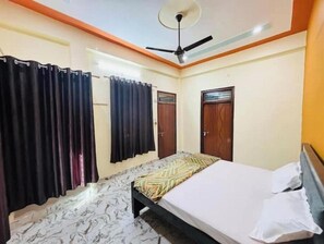 Cozy retreat with a bed, ceiling fan, and tiled floor.