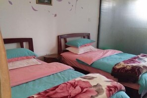 A bedroom with two single beds, each with a wooden headboard, and a window with a view of a tiled wall. - Dali Shuanglang Caiyunjian Inn (Dali City)