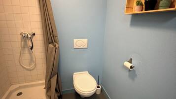 Een douche, handdoeken, toiletpapier