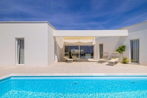 A modern house with a swimming pool, outdoor seating, and a covered patio. - Villa MENTA IV with pool (Linardići)