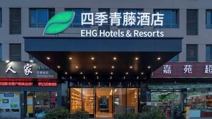 A hotel entrance with a modern design, featuring a prominent logo and signage for EHG Hotels & Resorts. - Four Seasons Qingteng Hotel (Ningbo Passenger Transport Center Airport) (Ningbo)