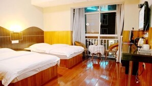 A hotel room with two beds, a desk, a chair, a window with curtains, and a view of the outside.
