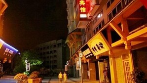 A building with a sign that reads "江南客馆" and a pedestrian crossing sign.