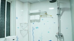 A bathroom with a shower, a towel rack, and a window.