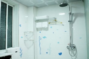 Un bagno con doccia, asciugamano e finestra.