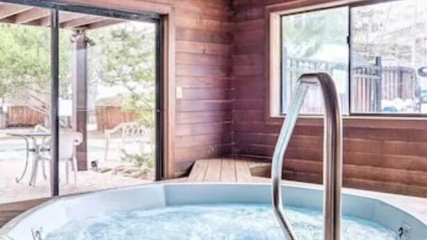 Ein Whirlpoolbereich mit Holzwänden und einer Glastür, die nach draußen führt.
