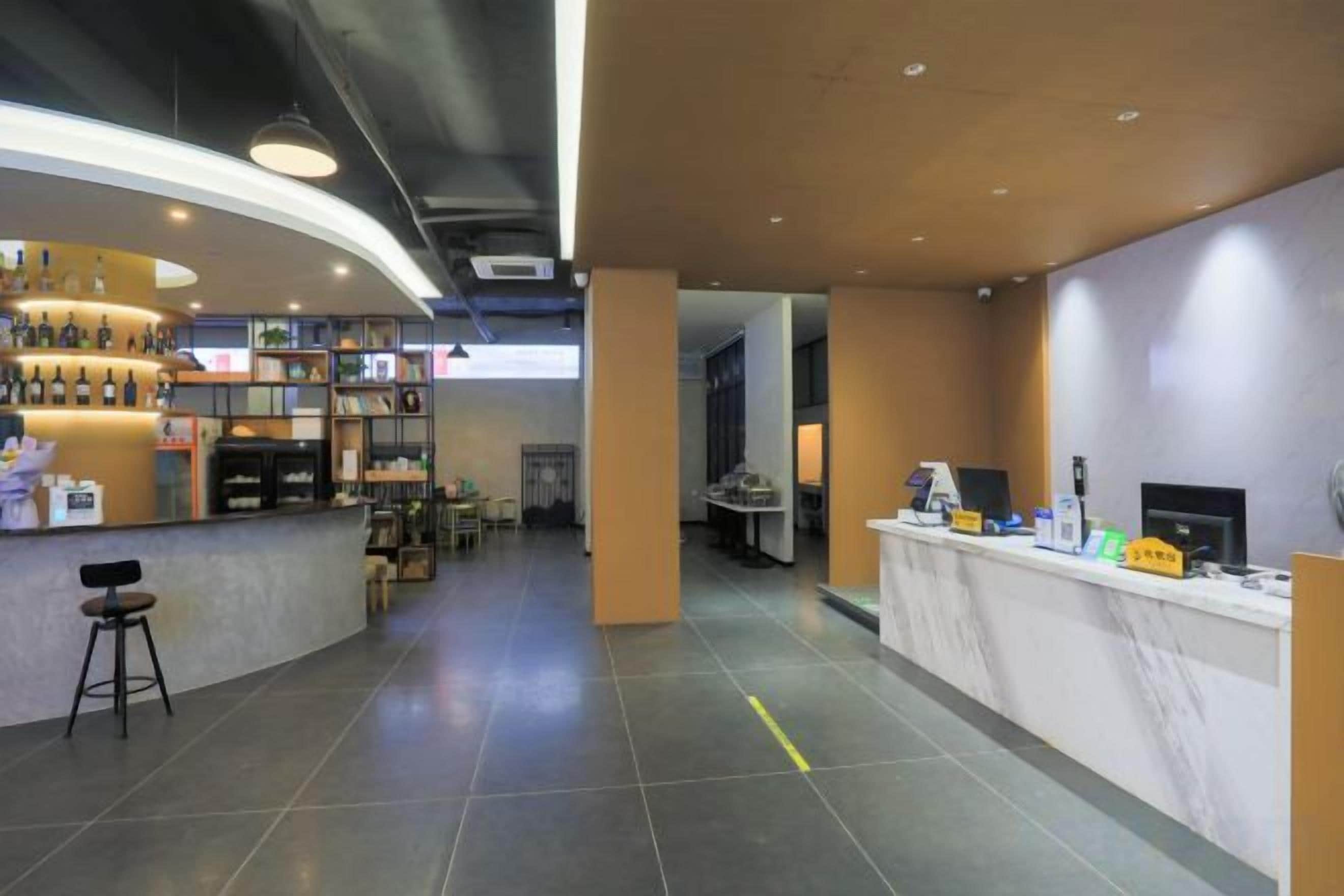 A hotel lobby with a reception desk, seating area, and a bar.
