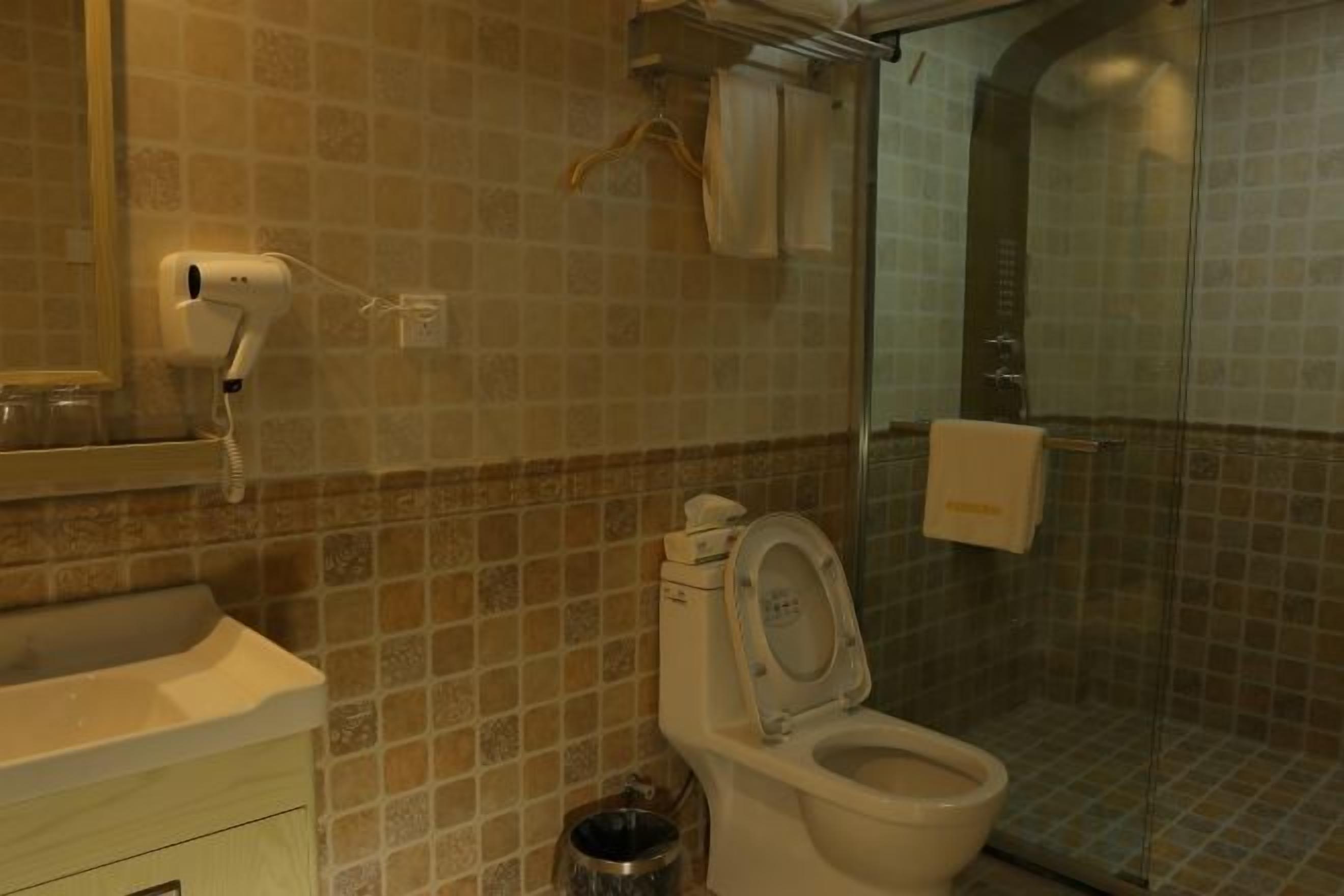 Une salle de bain comprenant des toilettes, un lavabo et un espace douche.