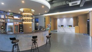 A modern bar area with a circular counter, bar stools, and a wine display. - Dongshan Zhuolan Resort Hotel (Dongshan County)