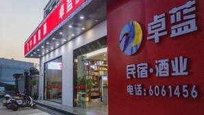 A building with a red sign and a logo. - Dongshan Zhuolan Resort Hotel (Dongshan County)