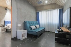 Una sala de estar moderna con un sofá, un televisor y una mesita.