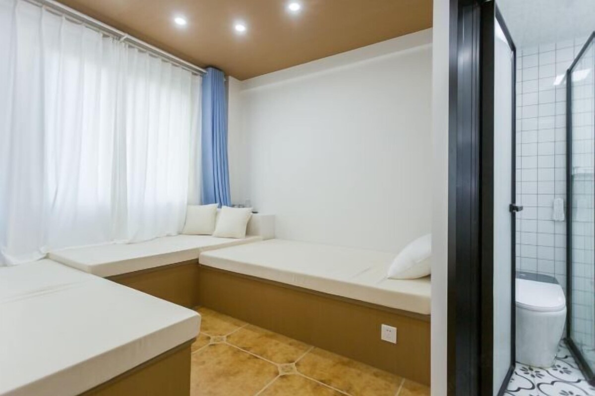 Una habitación pequeña y funcional con cama, banco y zona de ducha.
