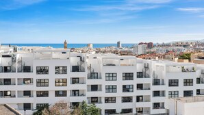 Un immeuble résidentiel moderne doté de nombreux balcons et offrant une vue dégagée sur la mer.