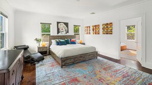 A bedroom with a large bed, a dresser, a nightstand, and a window. - Brookview Farm Country Living (Modena)