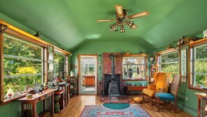 A cozy room with a brick fireplace, wooden furniture, and a large window. - Brookview Farm Country Living (Modena)