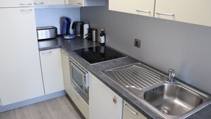 Une cuisine moderne équipée d’appareils électroménagers en acier inoxydable, d’un four encastré et d’un évier.