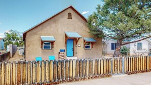 A single-story building with a brown exterior, a blue door, and two small windows with awnings. - Fantastic 3bd/2ba in N. Valley, Garage, near i40 (Albuquerque)