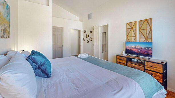 A bedroom with a large bed, a TV, and a dresser. - Fantastic 3bd/2ba in N. Valley, Garage, near i40 (Albuquerque)