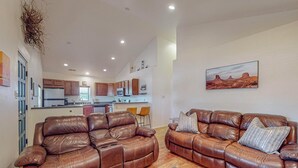 A spacious living room with two brown leather sofas, a wooden floor, and a kitchen in the background. - Fantastic 3bd/2ba in N. Valley, Garage, near i40 (Albuquerque)