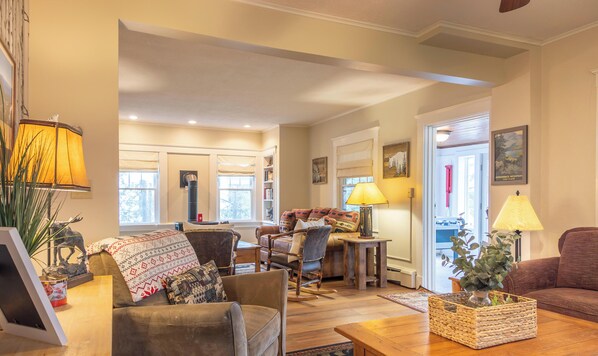 A cozy living room with a fireplace, comfortable seating, and a bookshelf.