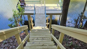 Eine Holztreppe führt zu einem Steg über dem Wasser.