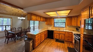 A kitchen with wooden cabinets, a granite countertop, and a stainless steel refrigerator.