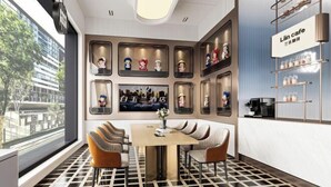 A modern cafe interior with a dining area, wall-mounted shelves with figurines, and a visible outdoor view. - Baiyulan Hotel (Shenzhen Railway Station & Laojie Metro Station Branch) (Shenzhen)