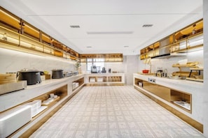 A modern kitchen with a central island, built-in ovens, and stainless steel appliances. - Magnotel Hotel(Shenzhen Railway Station & Laojie Metro Station Branch) (Shenzhen)