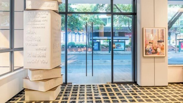 A hotel entrance with a glass door, a tiled floor, and a stack of books on the left. - Baiyulan Hotel (Shenzhen Railway Station & Laojie Metro Station Branch) (Shenzhen)