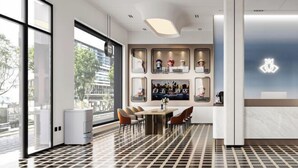 A modern hotel lobby with a reception desk, a seating area with chairs, and a large window offering a city view. - Baiyulan Hotel (Shenzhen Railway Station & Laojie Metro Station Branch) (Shenzhen)