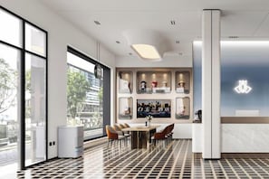 A modern hotel lobby with a reception desk, seating area, and large windows. - Magnotel Hotel(Shenzhen Railway Station & Laojie Metro Station Branch) (Shenzhen)