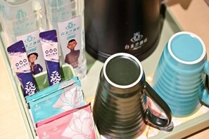 A tray with a black mug, several packaged items, and a black container. - Baiyulan Hotel (Shenzhen Railway Station & Laojie Metro Station Branch) (Shenzhen)