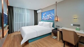 A modern hotel room with a large bed, a desk, and a chair. There is a painting on the wall, a TV, and a window with curtains. - Baiyulan Hotel (Shenzhen Railway Station & Laojie Metro Station Branch) (Shenzhen)