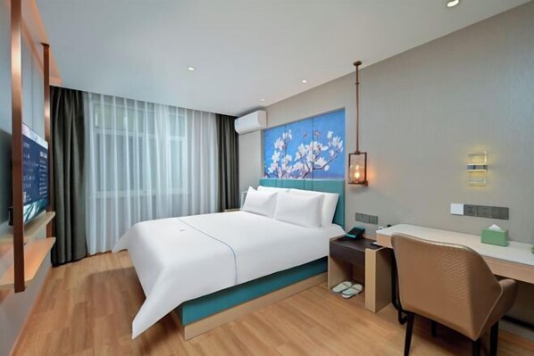 A modern hotel room with a large bed, a desk, and a chair. There is a painting on the wall, a TV, and a window with curtains. - Baiyulan Hotel (Shenzhen Railway Station & Laojie Metro Station Branch) (Shenzhen)