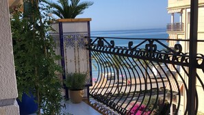 A balcony with a view of the sea, potted plants, and a tiled floor. - Calafell Beachfront Escape. Spacious Attic with Rooftop Terrace and Pool. (CT)