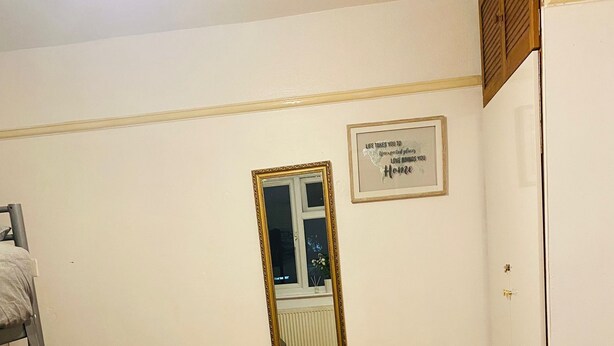 A room with a wooden floor, a ladder, a framed mirror, and a wall with a framed quote. - Cosy Double room - 2 guests -Close to central London-5minsHarrow and Wealdstone  (Harrow)