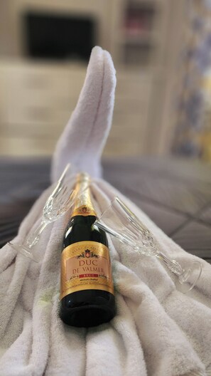 A bottle of DUC De Valmer Brut wine on a white towel.
