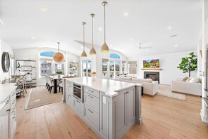 Una cocina amplia con una isla grande, iluminación colgante y vistas a la ciudad.
