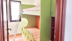 A bunk bed room with a ladder, a window with lace curtains, and a green wardrobe. - Hadley House Key to Villas (Viddalba)