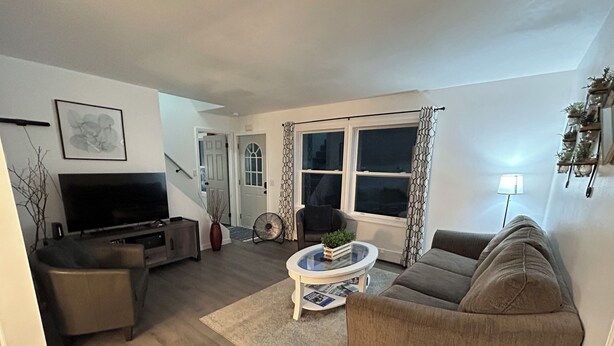 Una sala de estar con sofá, televisor y una mesa de centro.
