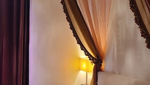 A bed with a canopy, a bedside table with a lamp, and an air conditioning unit on the wall. - B&B Ma Maison Govone  (Govone)