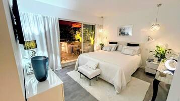 Een moderne slaapkamer met een groot bed, nachtkastje en uitzicht op de omgeving.