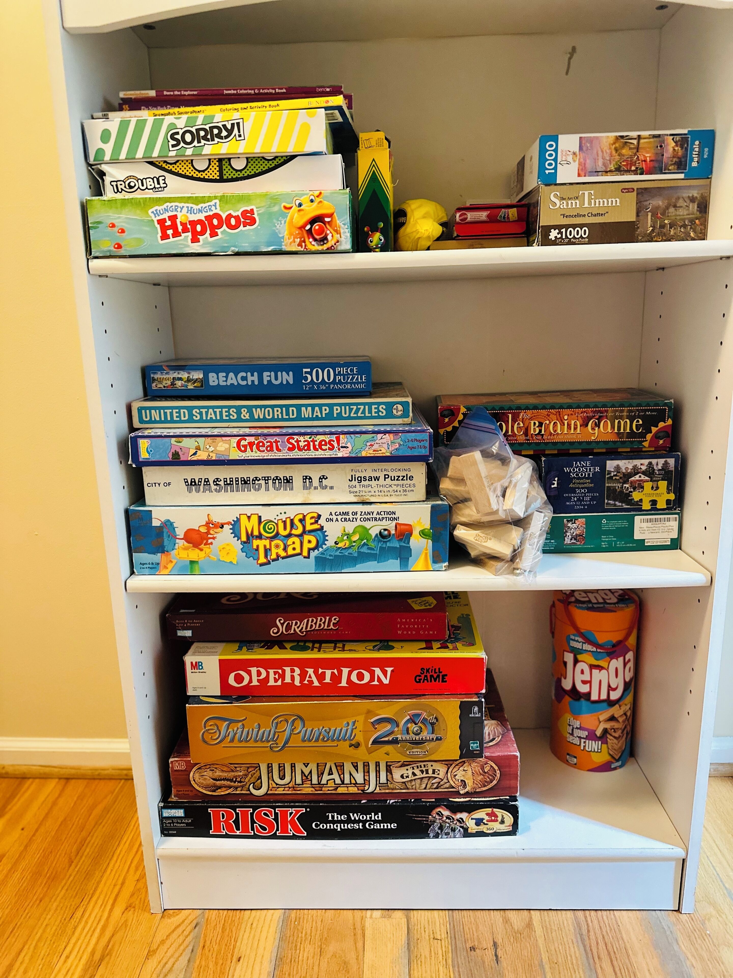 Ein Bücherregal mit verschiedenen Gesellschaftsspielen und Puzzles.
