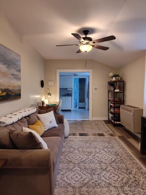 A living room with a sofa, a ceiling fan, a rug, and a bookshelf. - Berkshires! Dog & Family Friendly, Hot Tub, Hiking, Lakes-Swimming, Canoeing (Becket)