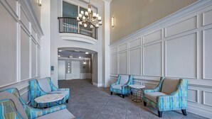 A spacious lobby with a high ceiling, a chandelier, and a view of a second-floor balcony. - VC6-105 - 3BR condo Resort Access near Disney (Orlando)